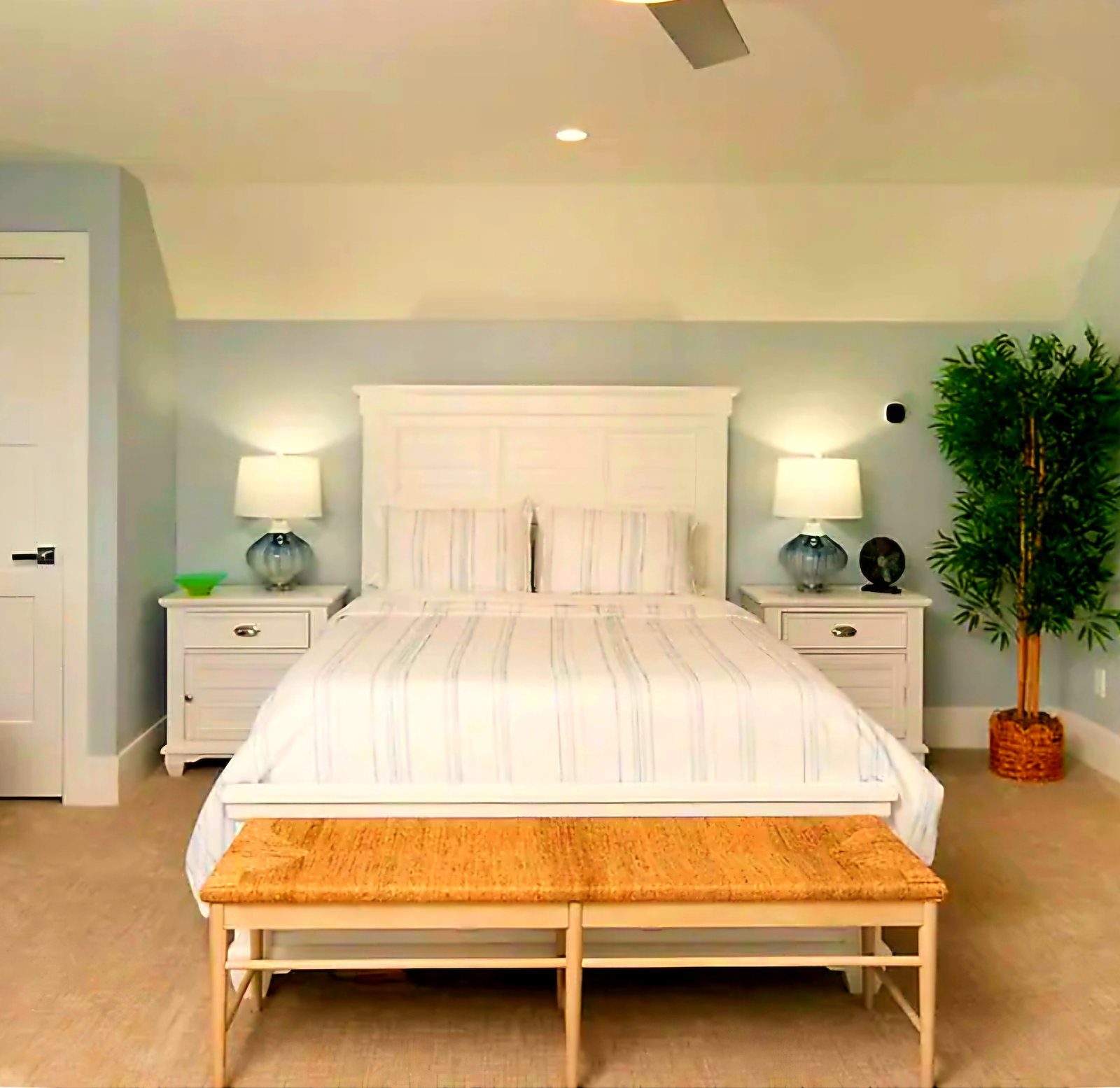 Plush king bed with striped linens and white headboard